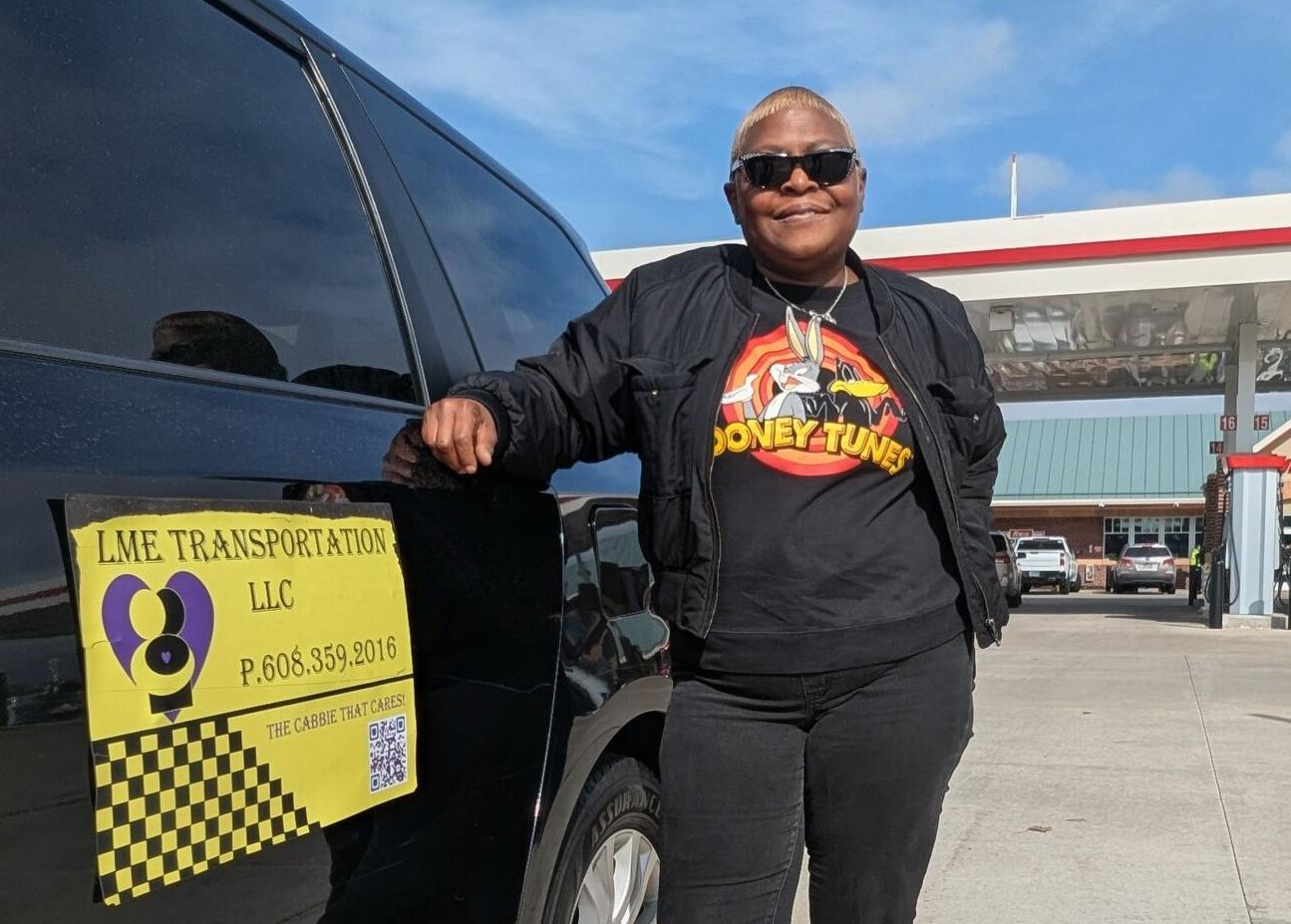 Michelle standing beside an LME Transportation passenger van in Janesville.